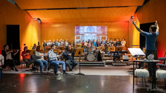 Auf dem Foto sind der Kinder- und Jugendchor des Gymnasiums, Musiker des Loh-Orchesters Sondershausen und der Band sowie der Dirigent Martin Bosch zu sehen.